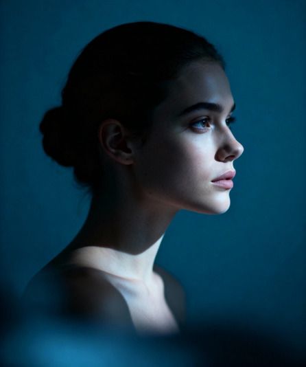 Femme de profil, chignon, fond bleu pétrole