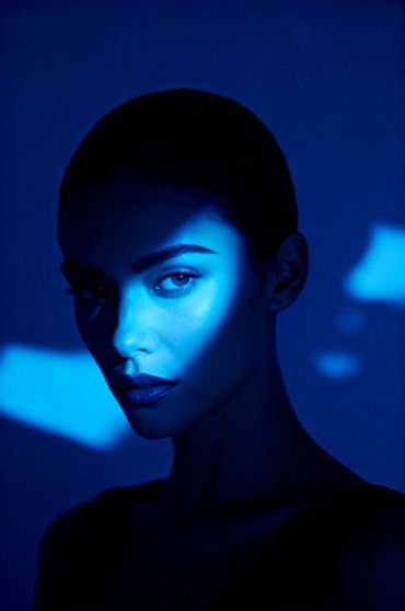 Femme en clair-obscur, lumière bleue découpée sur le visage