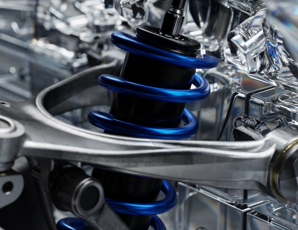 Détail de la suspension : ressort bleu au centre, bras en aluminium en gros plan