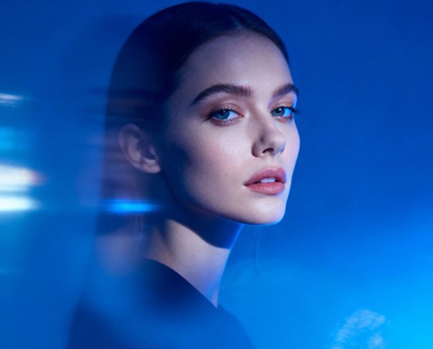 Femme de trois quarts, lumière bleue et filé de lumière