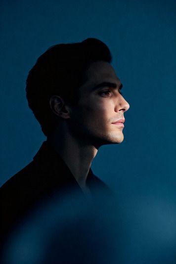 Homme de profil, cheveux en arrière, fond bleu pétrole