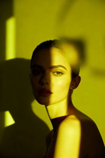 Femme de trois quarts, lumière jaune et ombres découpées