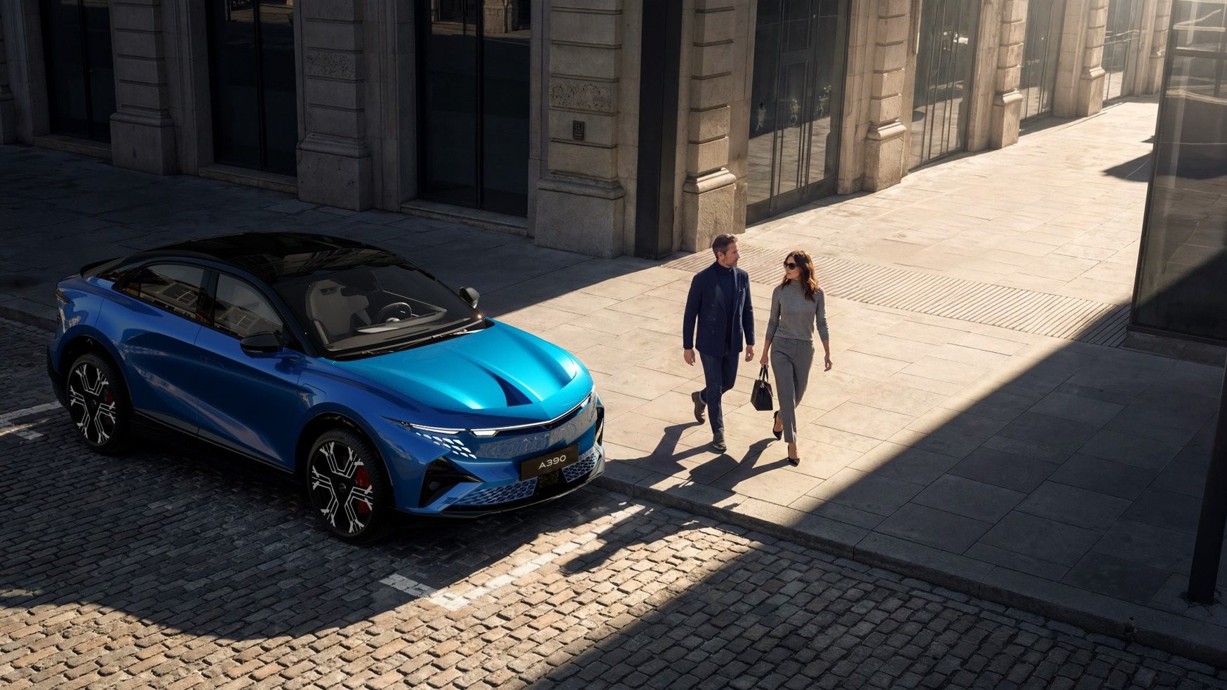 A390 bleue garée dans une rue pavée, un couple passe sur le trottoir au soleil